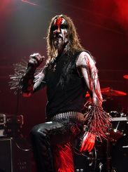 Lead singer of death metal band god seed at a show in demonic dress and red face paint 